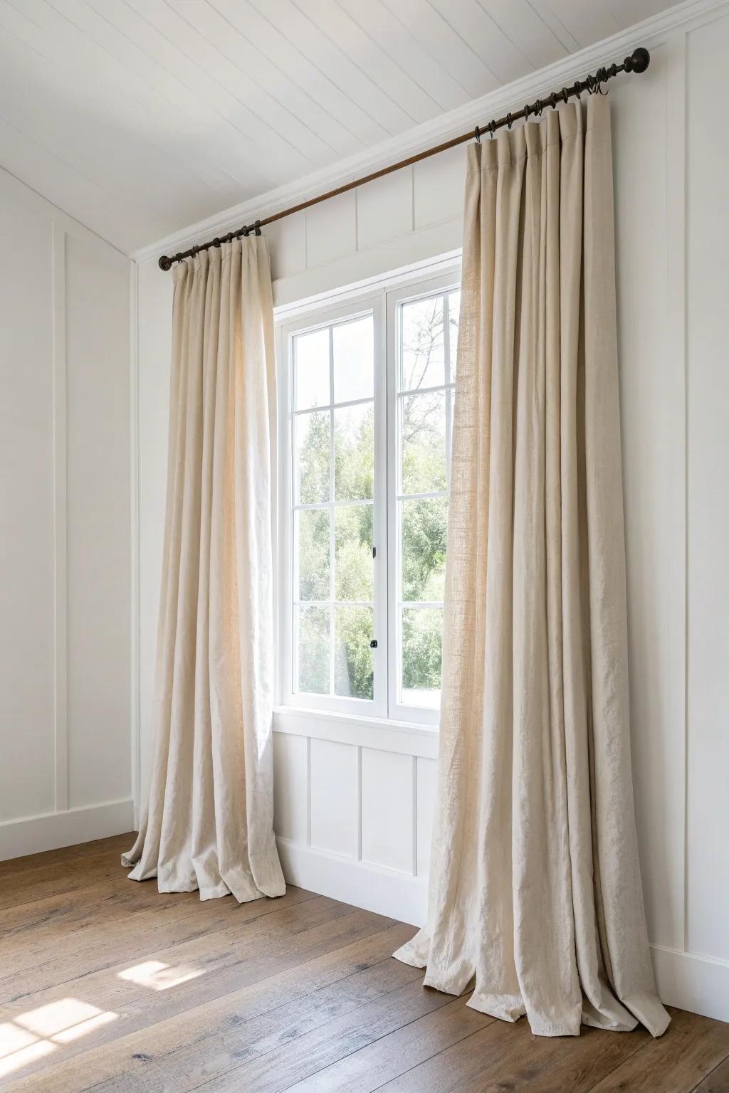 Hang curtains high and wide—floor-length linen instantly makes 8-foot walls feel taller.