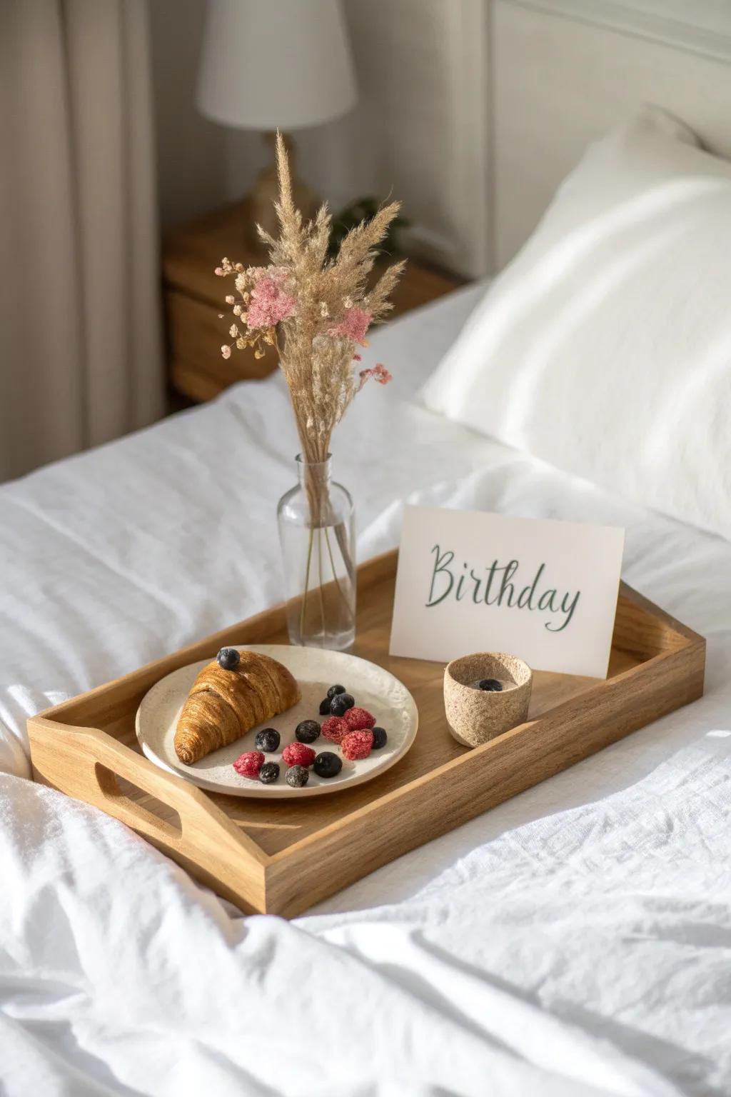A simple birthday tray on the duvet: snacks, card, and a tiny bouquet—hotel-ready joy.
