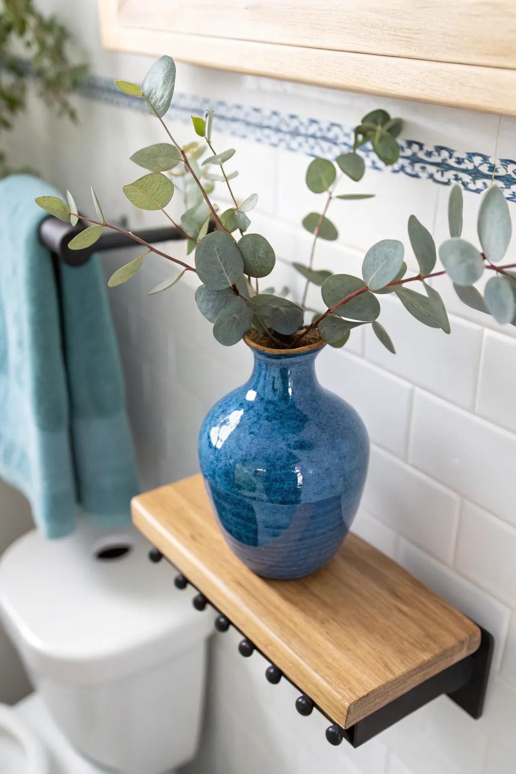 Make over-the-toilet shelves feel styled: one statement vase at eye level, extras above.