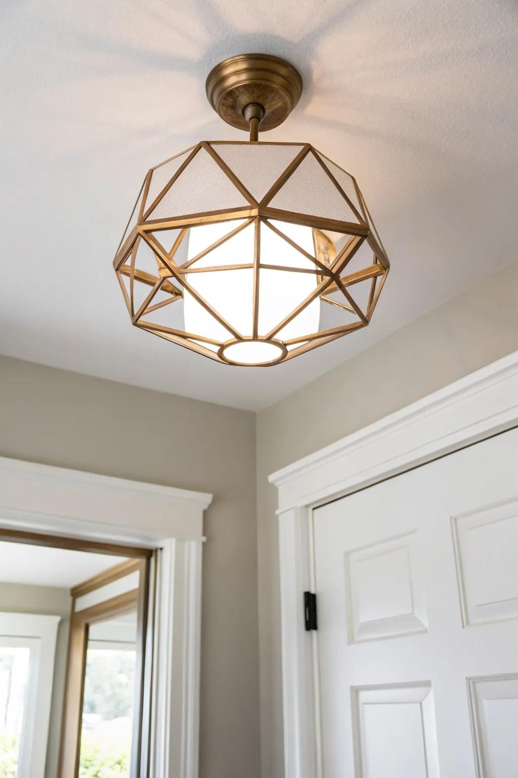 A geometric flush mount turns a tiny entry into a mini statement—clean lines, warm brass glow.