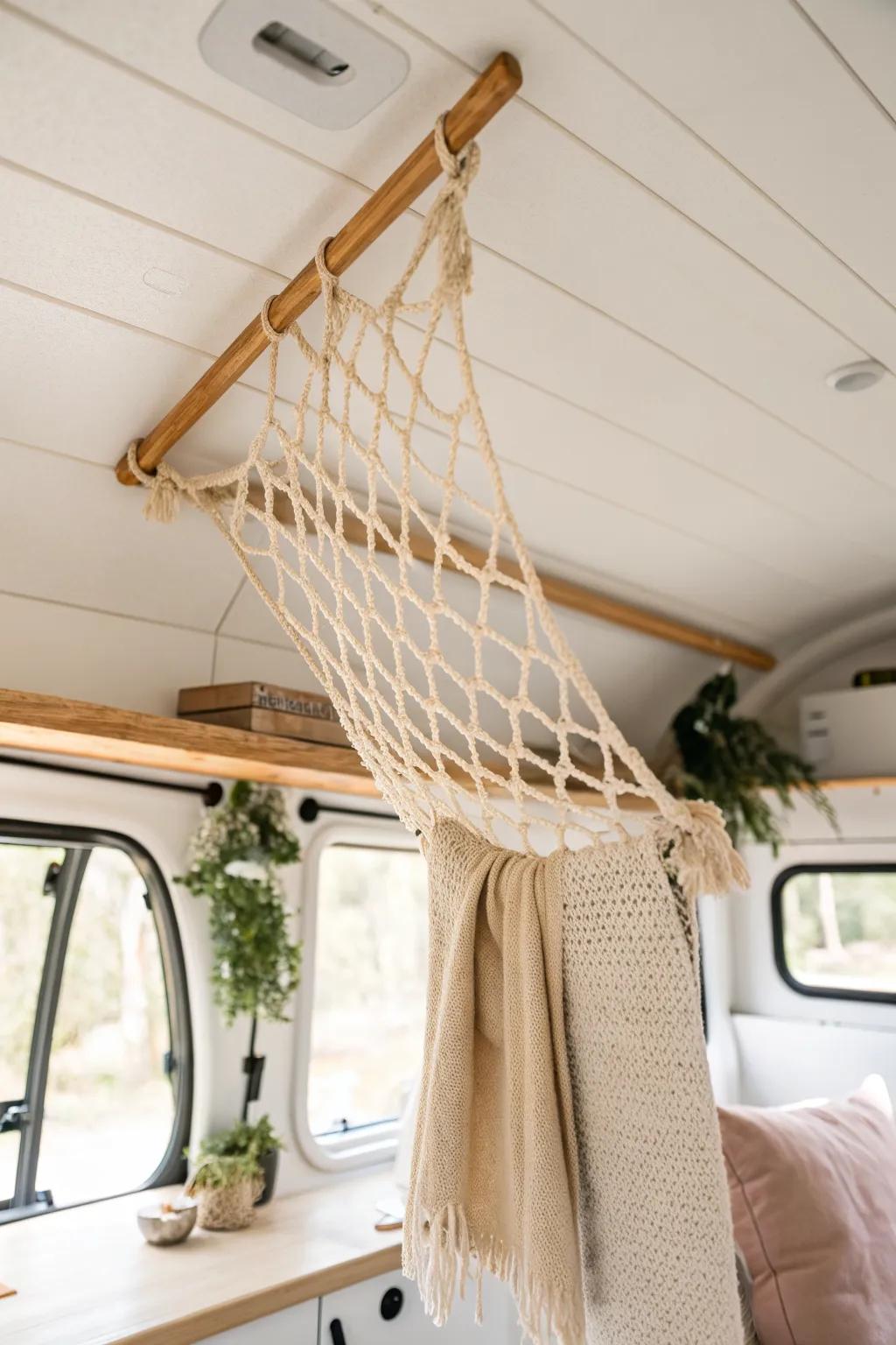 A ceiling cargo net keeps cozy throws off the floor—light, pretty storage for tiny RV living.