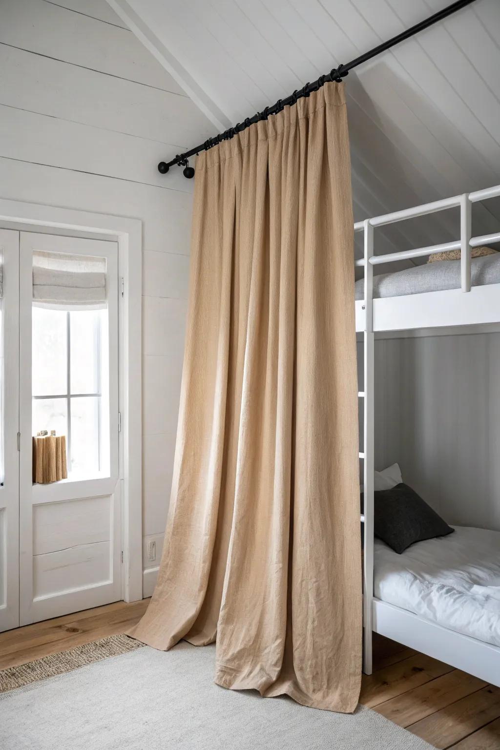 A linen curtain under the loft bed hides messy storage fast—calm, minimal, and chic.