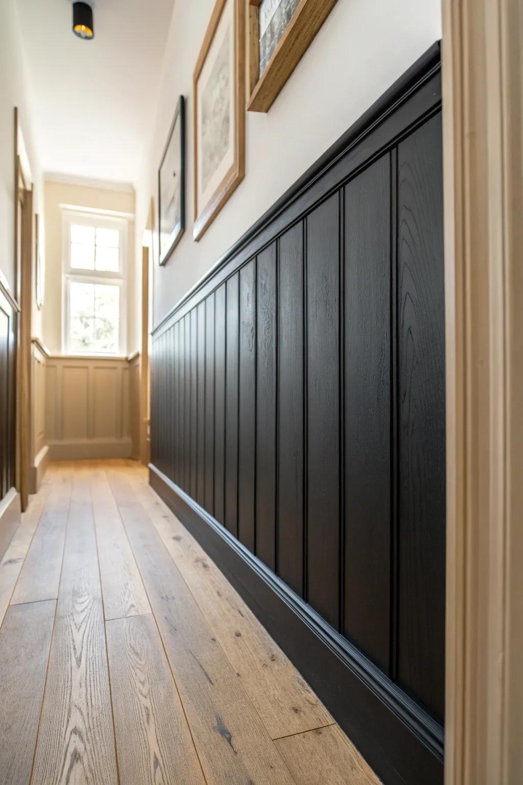 Black wainscoting with a light upper wall adds height and structure to a narrow hallway.