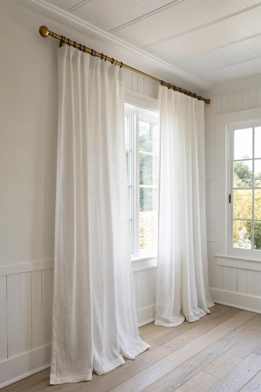 Hang sheer curtains high to stretch your windows and let soft, cozy light fill a small bedroom.