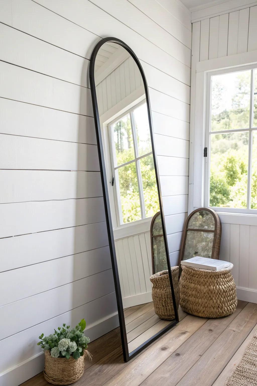 A tall arched mirror opposite the window doubles light and makes narrow mobile spaces feel deeper.
