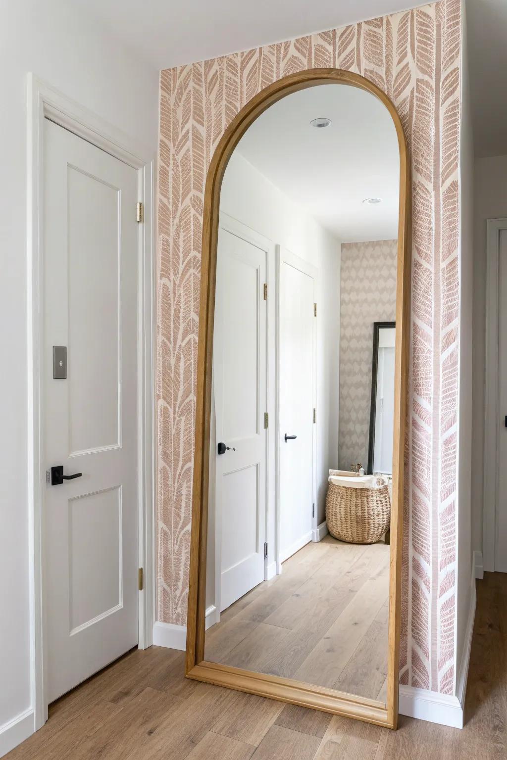 A single wallpaper runway behind an oak arch mirror turns a tiny entry into a statement.