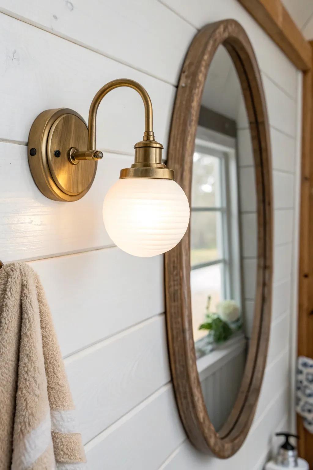 Warm brass wall sconce beside the mirror for shadow-free, boutique-style vanity lighting.