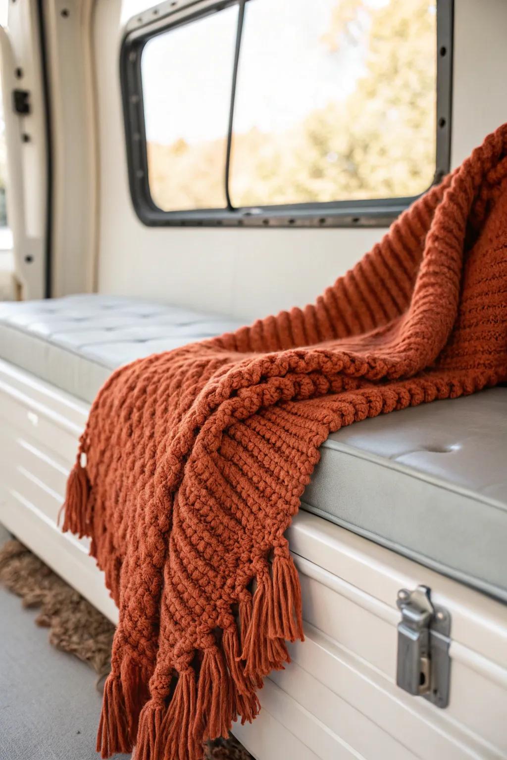 A chunky knit throw in bold terracotta instantly turns toy-hauler garage vibes cozy.