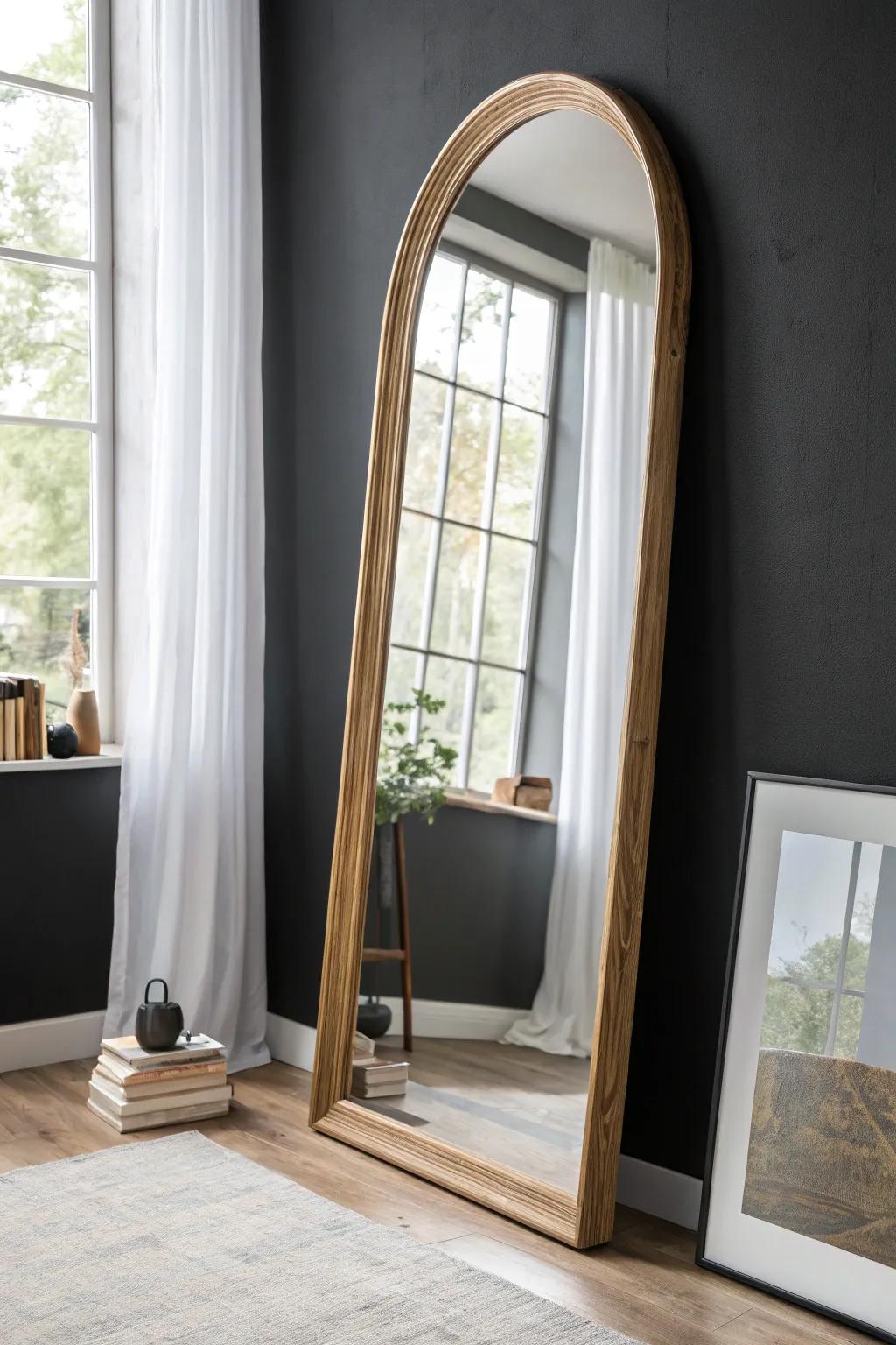 One oversized mirror makes a black wall feel brighter, bigger, and beautifully intentional.