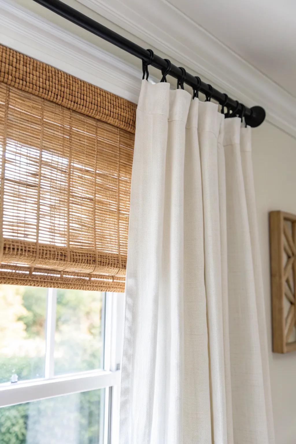 Layer a woven shade with soft linen drapes for instant privacy and cozy nighttime glow.